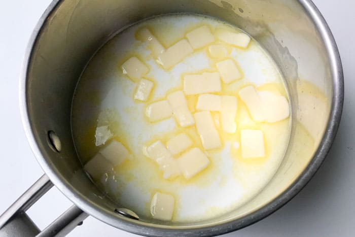 Step 1 of choux pastry, milk, water, butter coming to a boil