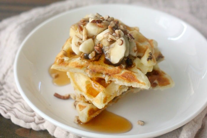 Waffles topped with banana, pecans and syrup