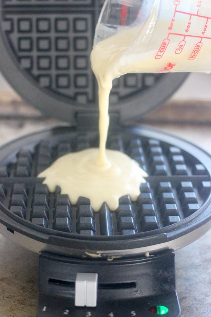 Pouring the batter from the easy waffle recipe into the waffle maker