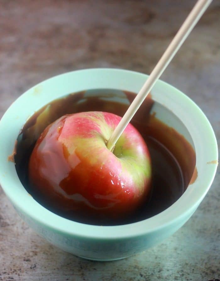 Apple being coated in caramel